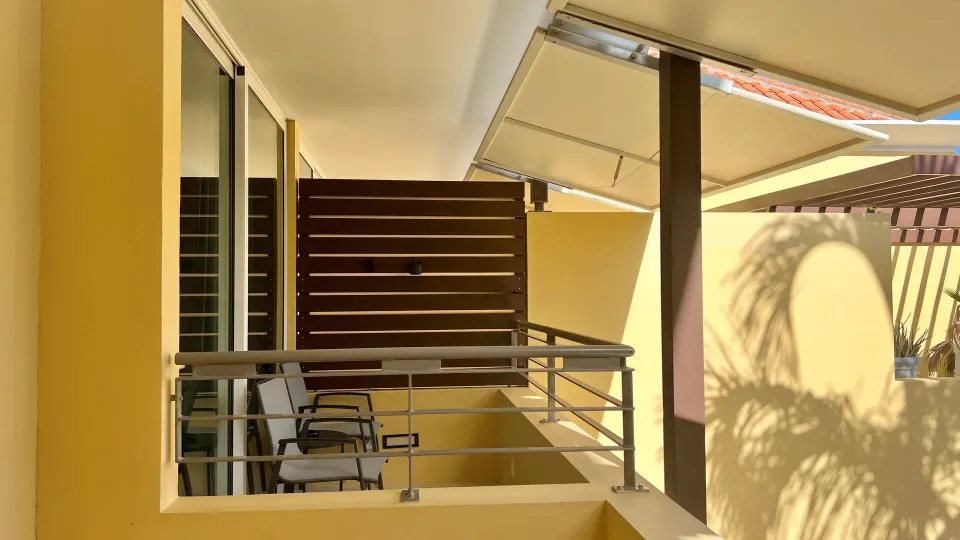 Standard Room octagon balcony with chairs and privacy screen at Avila Beach Hotel.