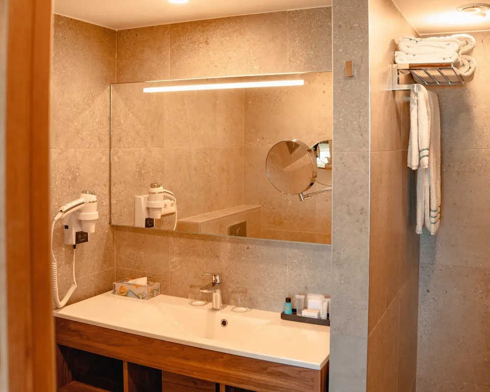 Standard Room octagon bathroom vanity with mirror and towels at Avila Beach Hotel.