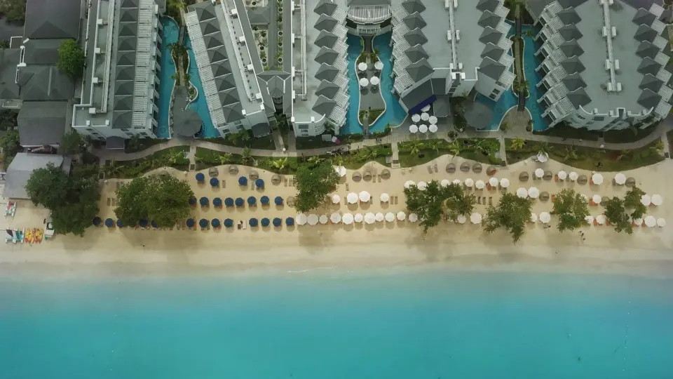 Aerial view of the beachfront, loungers, pools, and resort buildings at Azul Beach Resort Negril.