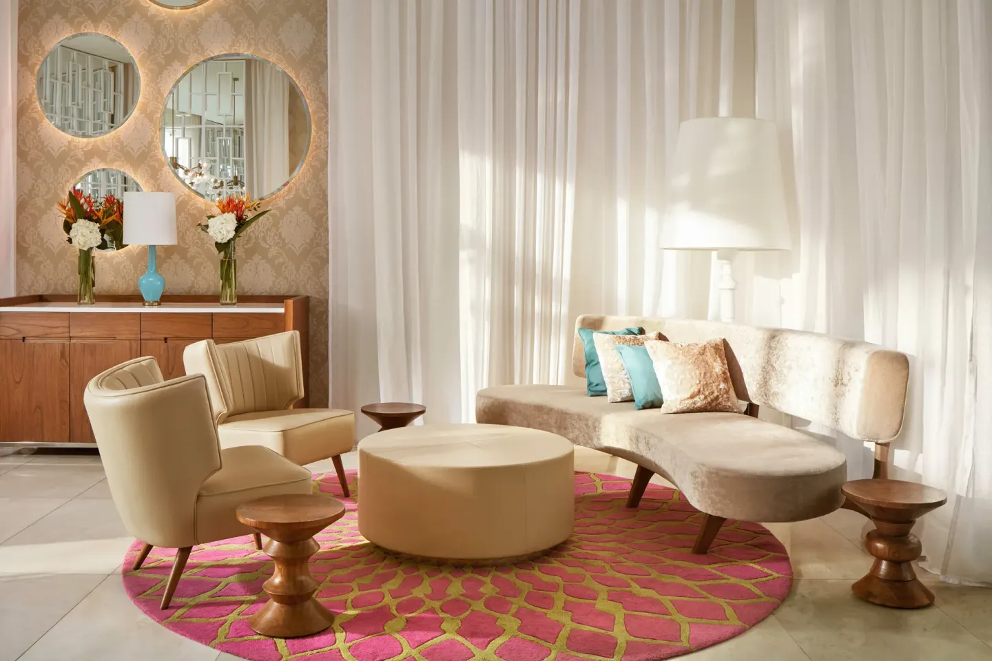 Lounge seating with round mirrors and white curtains at Azul Beach Resort Negril.