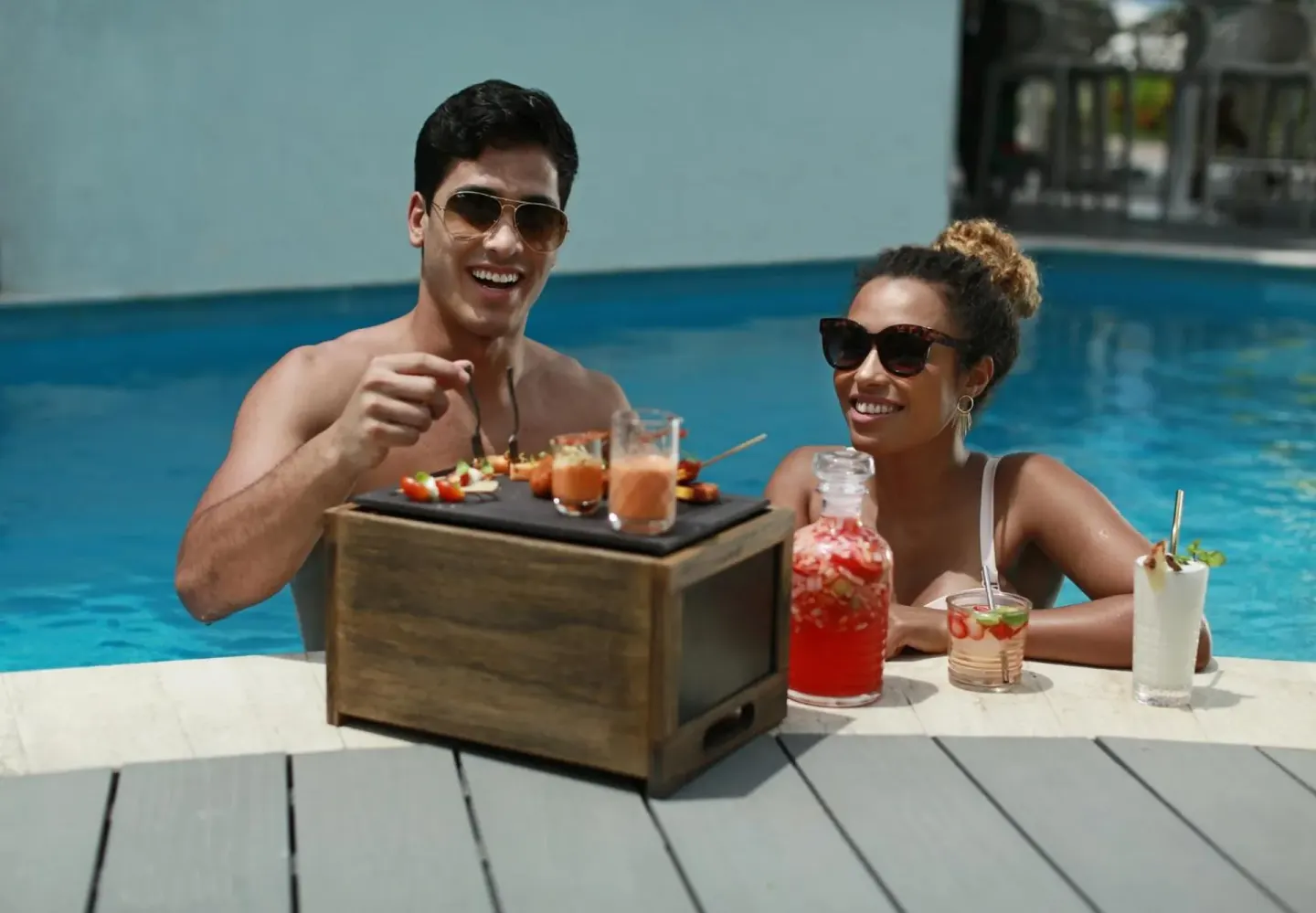 Guests in a pool with drinks and snacks at Azul Beach Resort Negril.