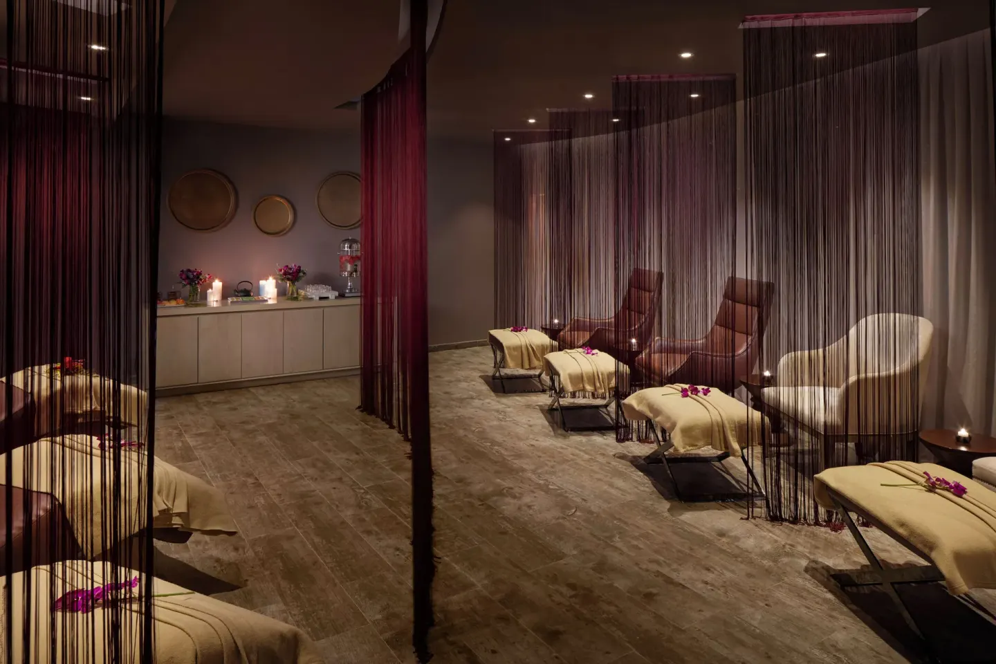 Spa relaxation room with loungers, curtains, candles, and flowers at Azul Beach Resort Negril.