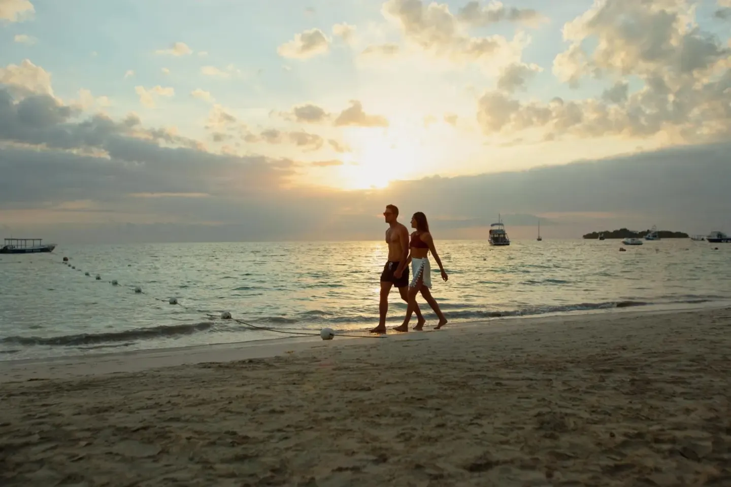 Couple walking along the beach at sunset at Azul Beach Resort Negril.