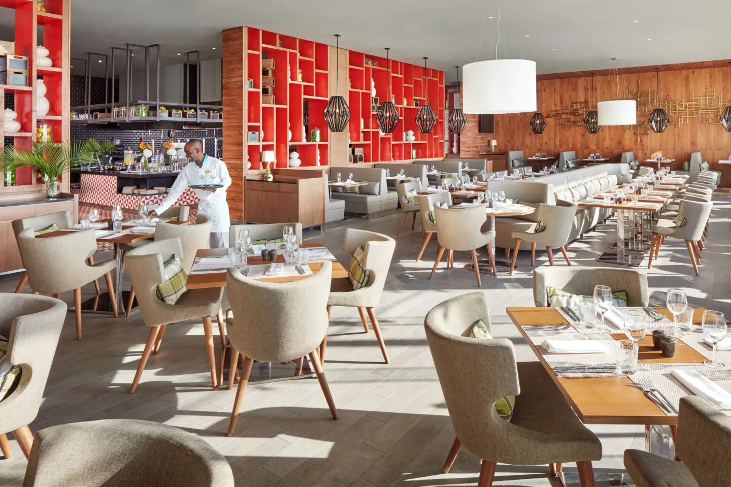 Modern restaurant dining room with set tables and red shelving at Azul Beach Resort Negril.