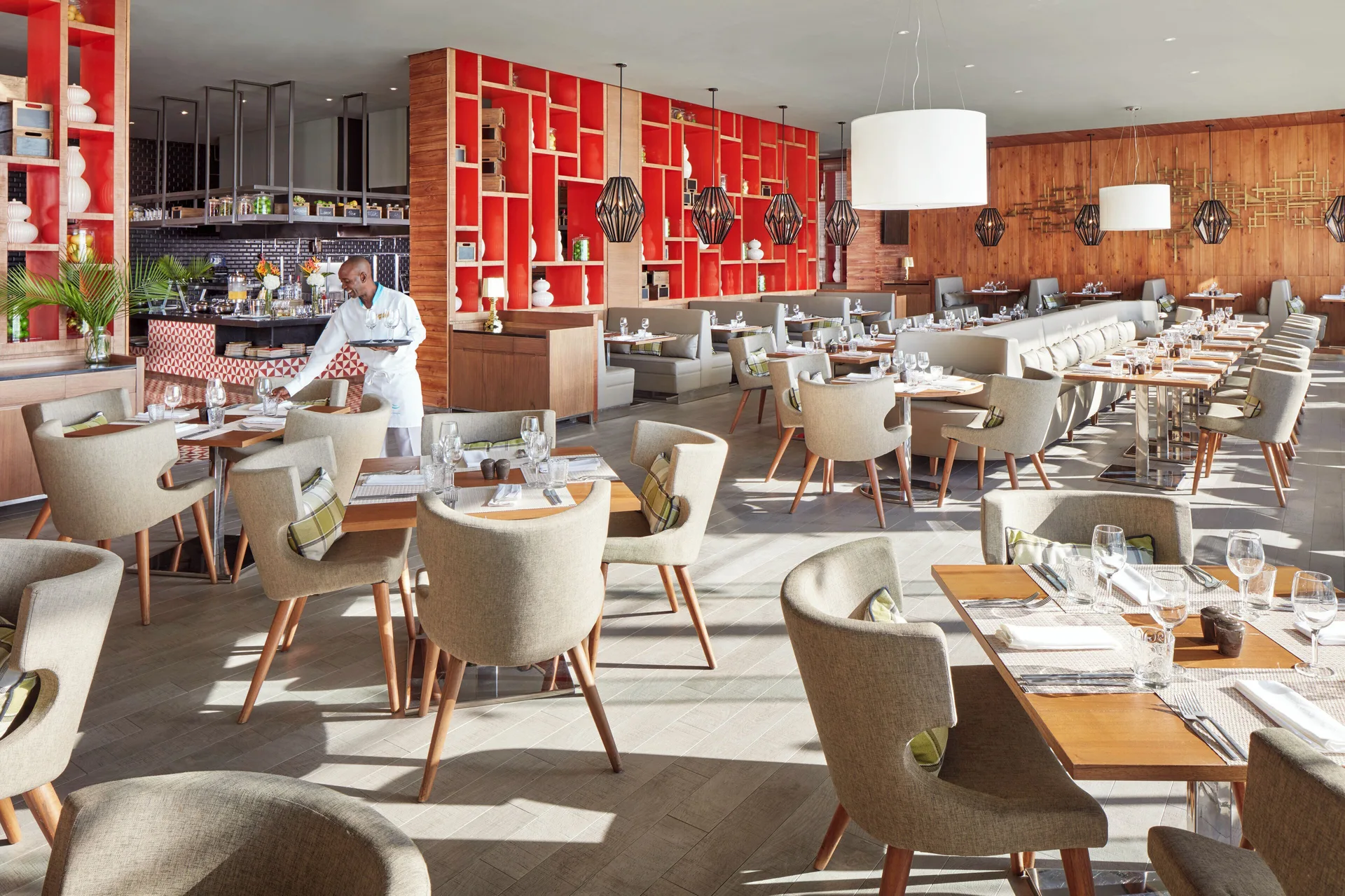 Modern restaurant dining room with set tables and red shelving at Azul Beach Resort Negril.