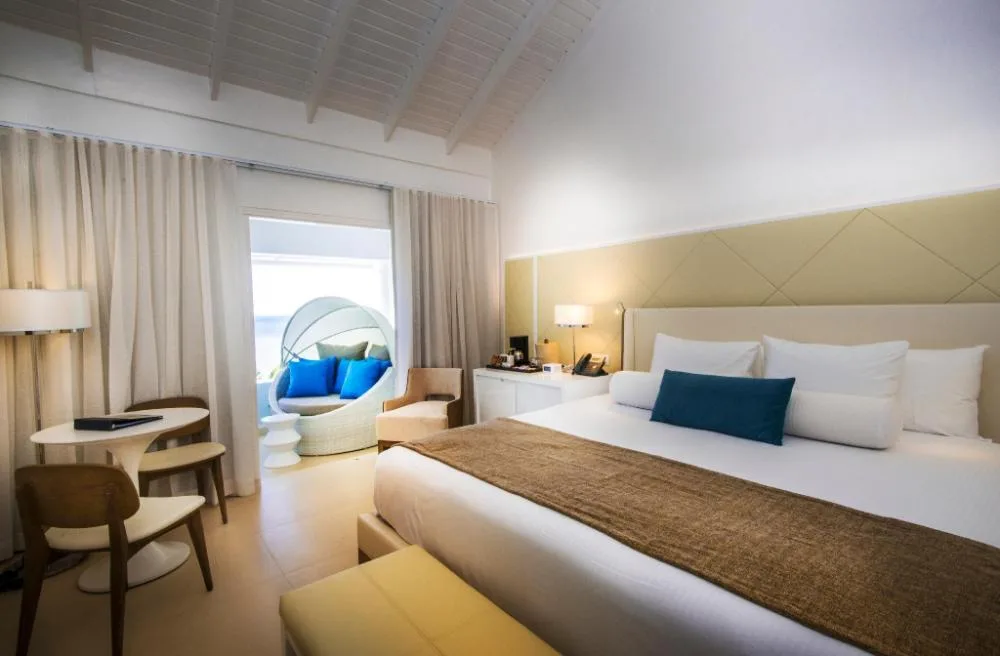 Ocean View Deluxe Room king bed and balcony seating at Azul Beach Resort Negril.