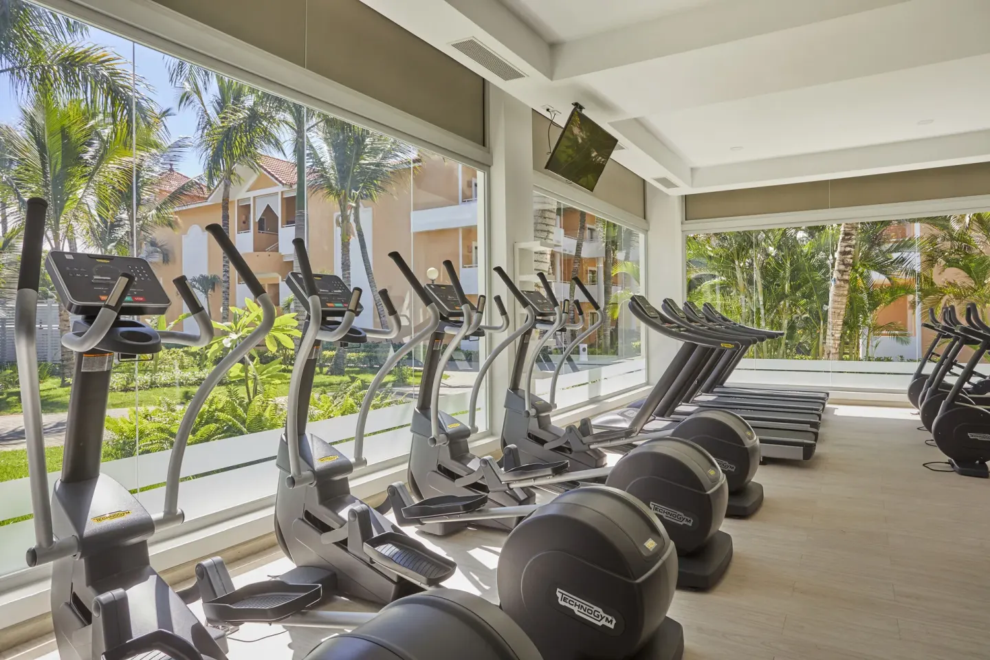 Fitness room with cardio machines and garden views at Bahia Principe Escape Ambar.