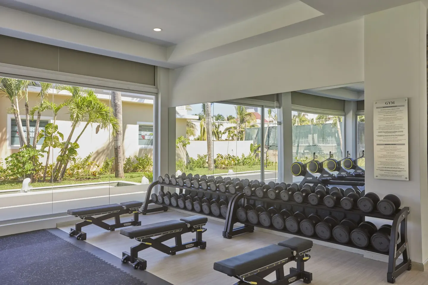 Dumbbell racks and benches in the gym at Bahia Principe Escape Ambar.