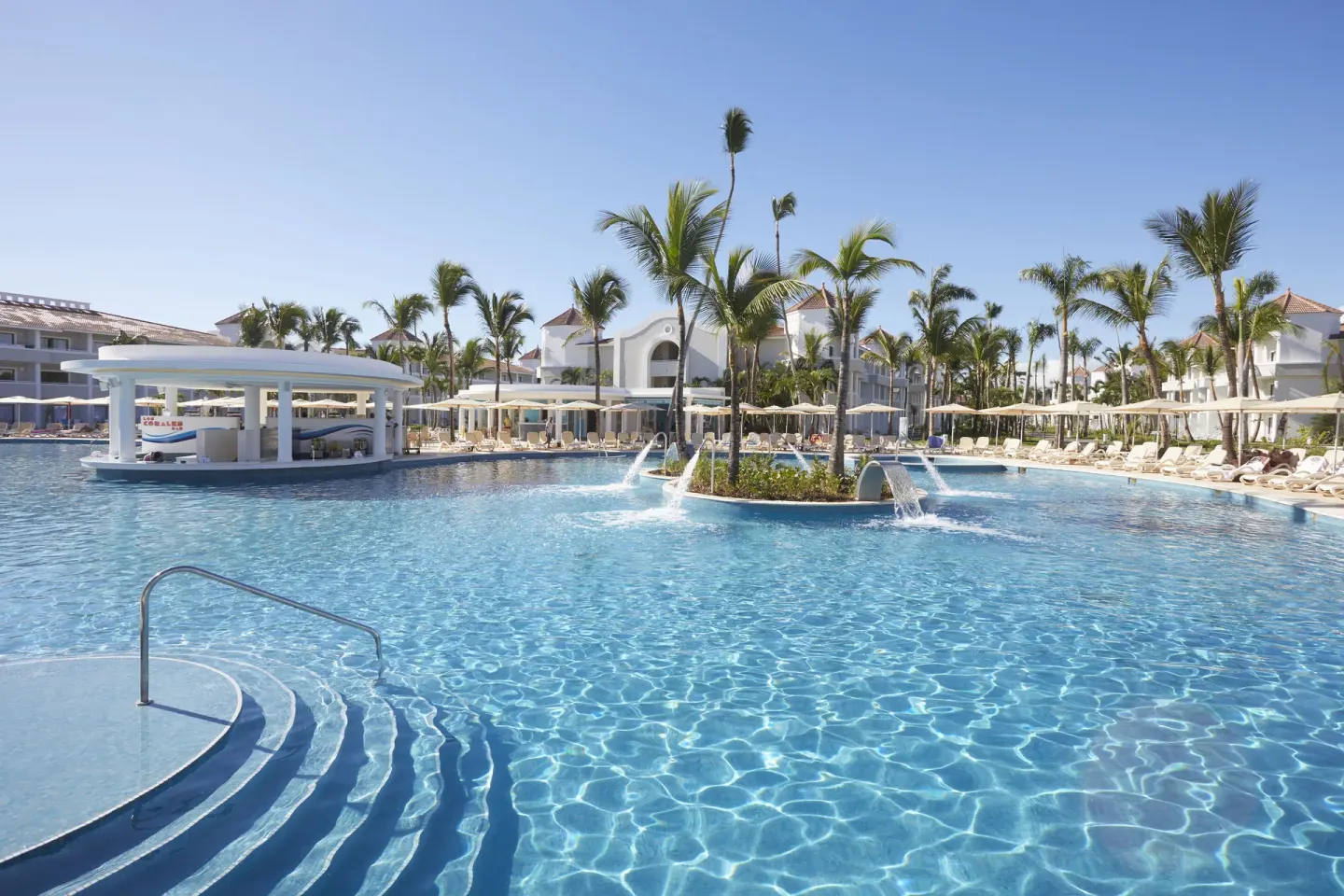 Large resort pool with palms and water features at Bahia Principe Escape Ambar.