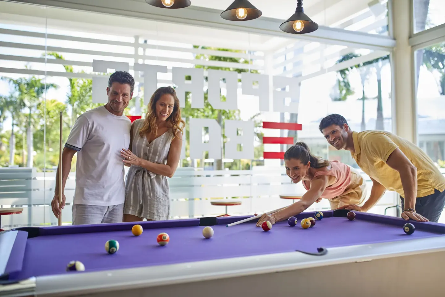 Guests playing pool in a bright lounge at Bahia Principe Escape Ambar.