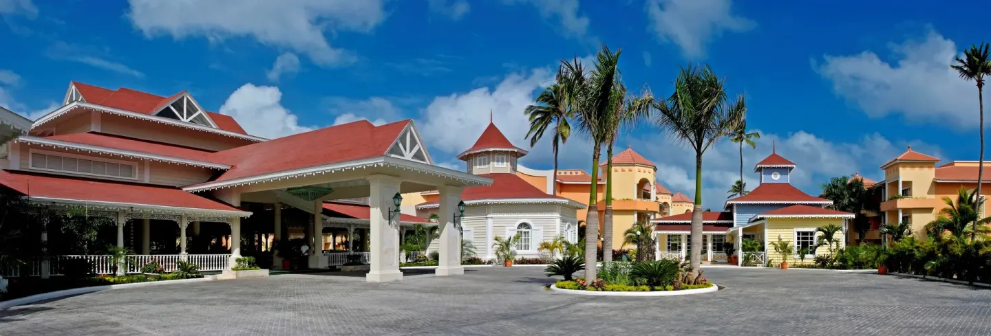 Resort entrance driveway and red-roofed buildings at Bahia Principe Escape Ambar.