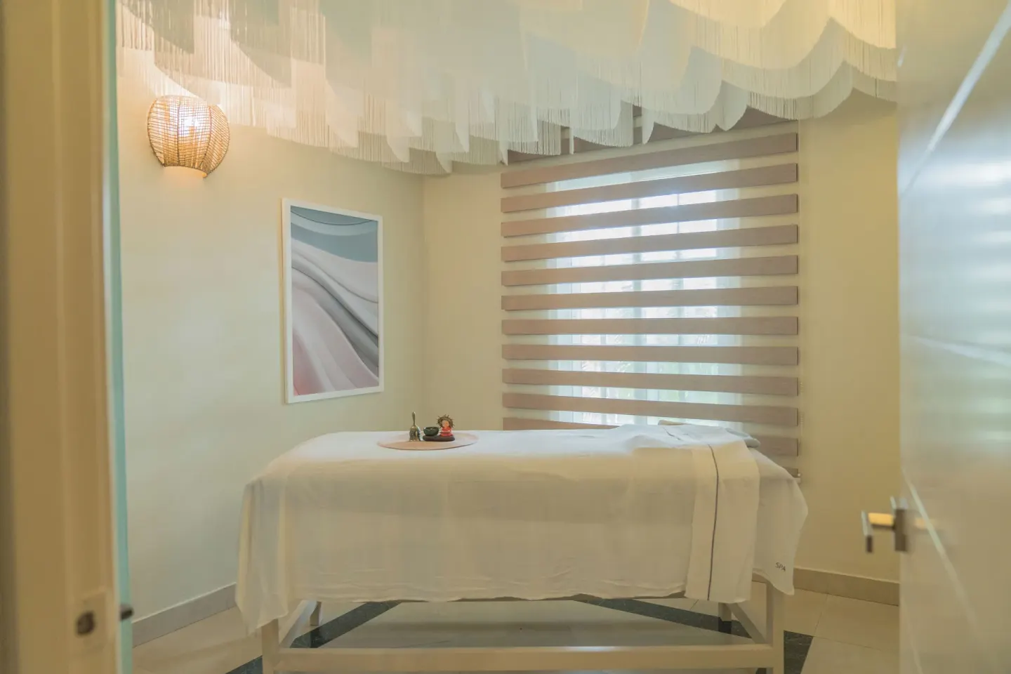 Massage treatment room with a single table at Bahia Principe Escape Ambar.