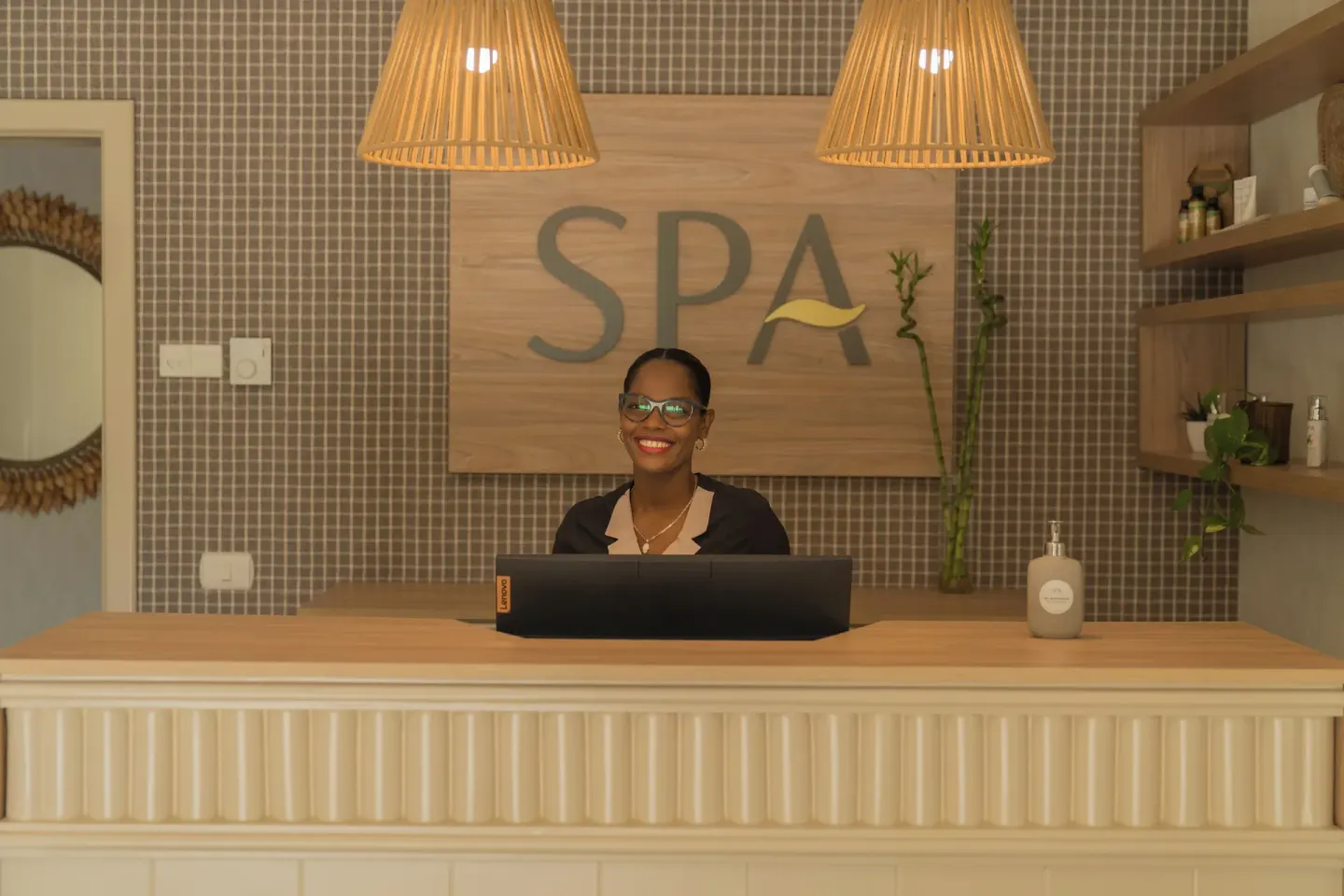 Smiling spa attendant at the reception desk at Bahia Principe Escape Ambar.