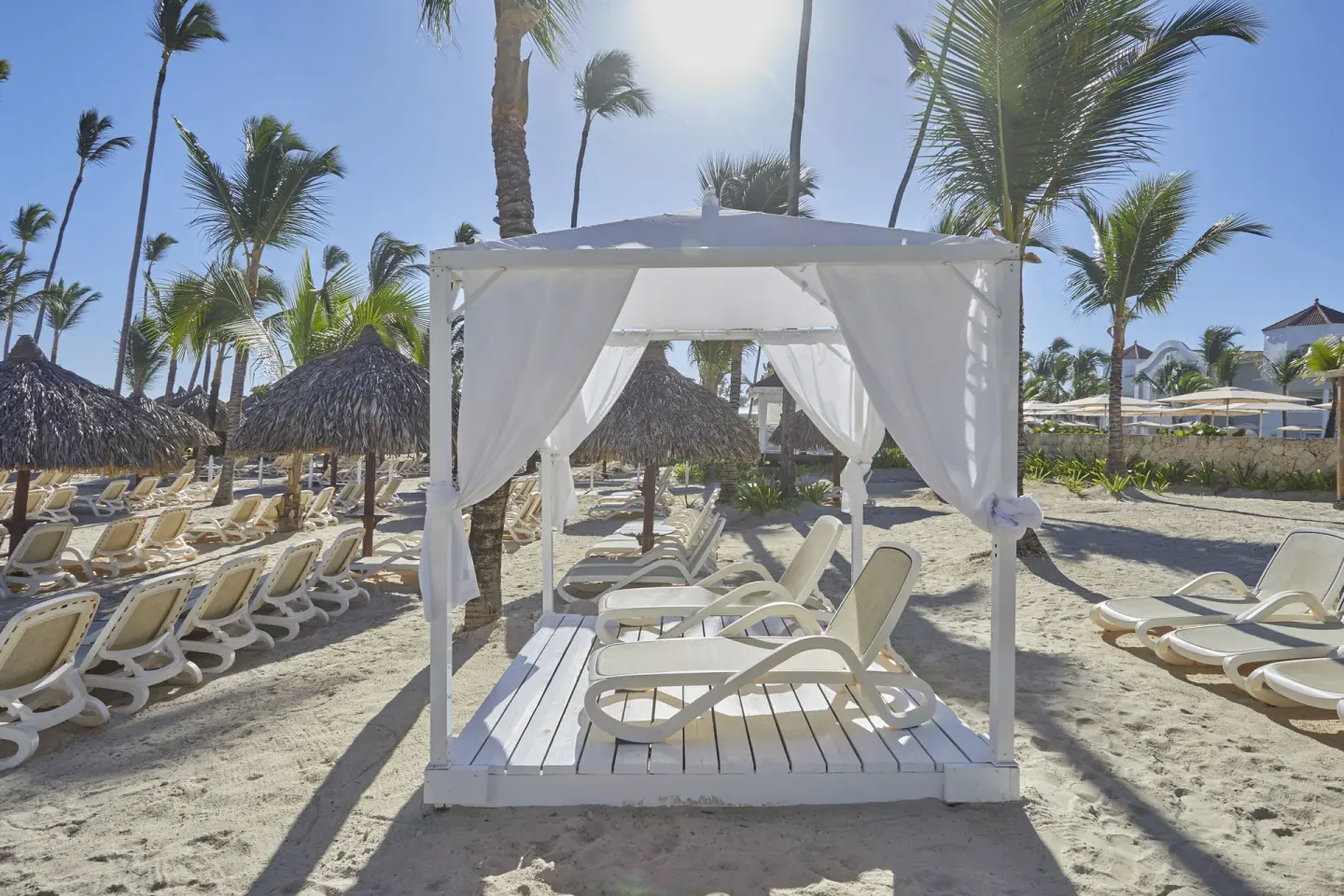 White beach cabana with lounge chairs at Bahia Principe Escape Ambar.