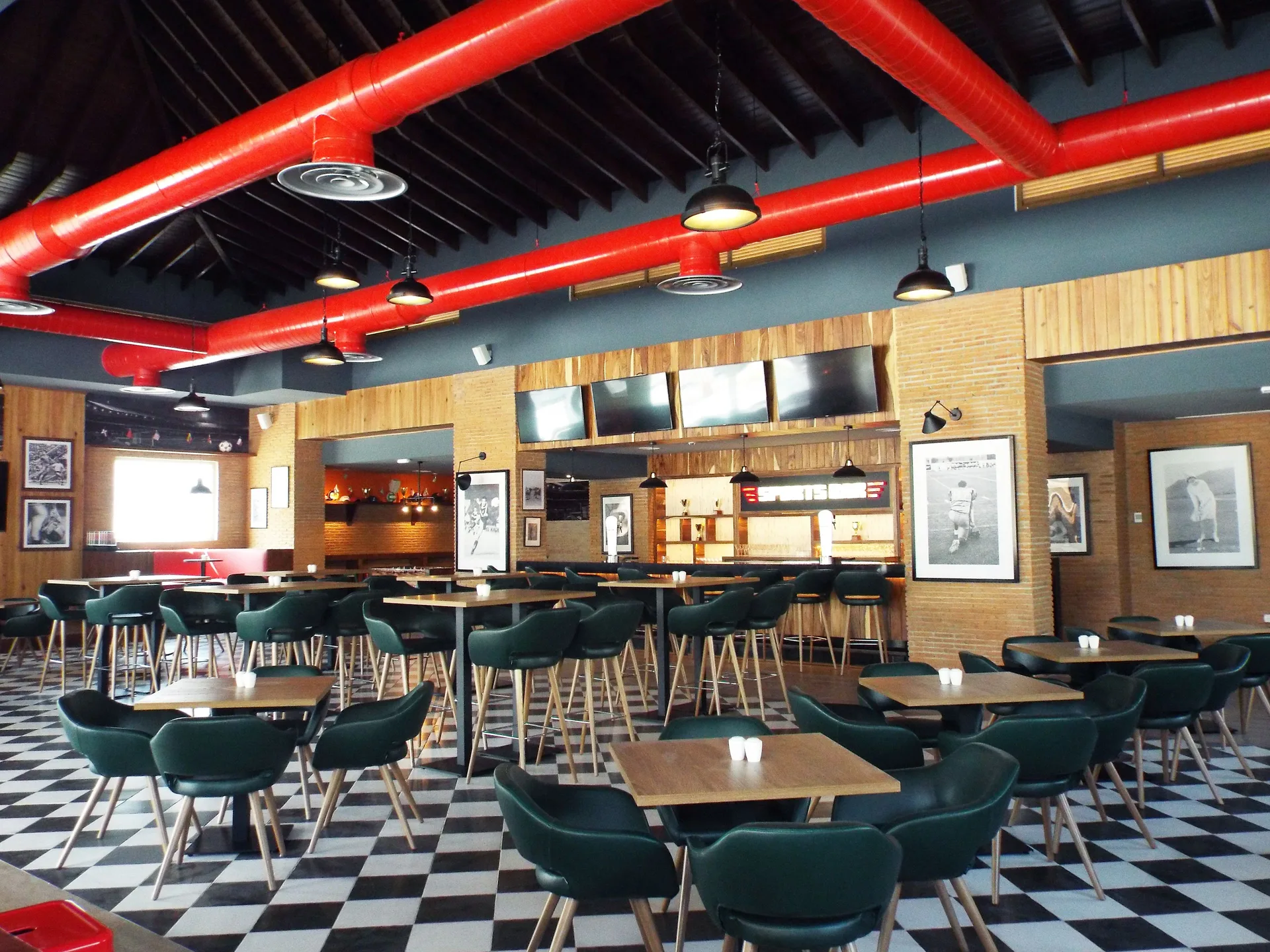 Casual grill-style dining room with red ceiling ducts at Bahia Principe Escape Ambar.