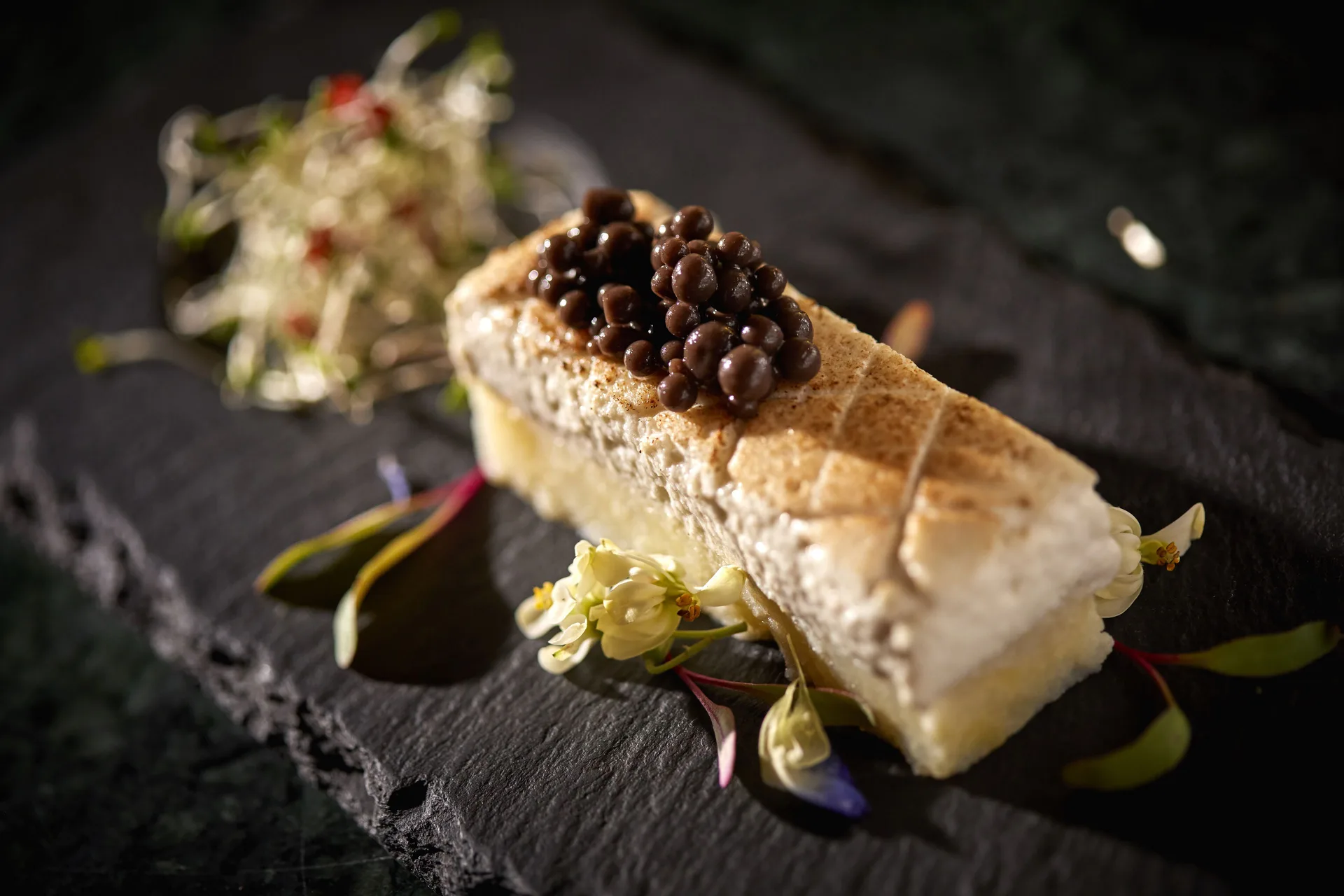 Plated dessert on a dark slate at Bahia Principe Escape Ambar.