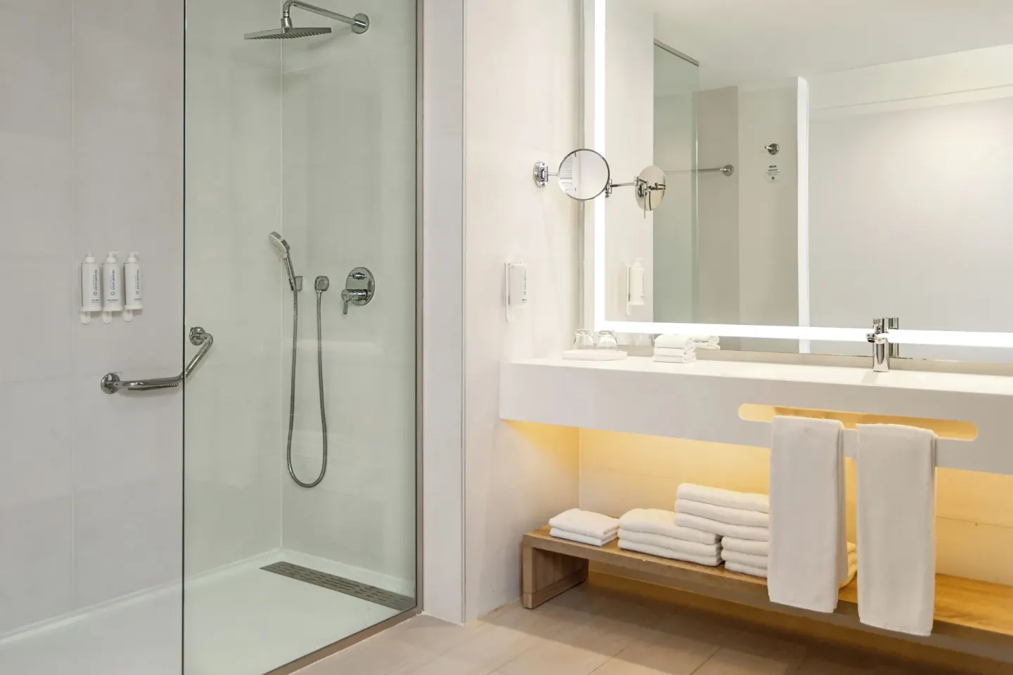 Corner Junior Suite bathroom with glass shower and vanity at Bahia Principe Escape Ambar.
