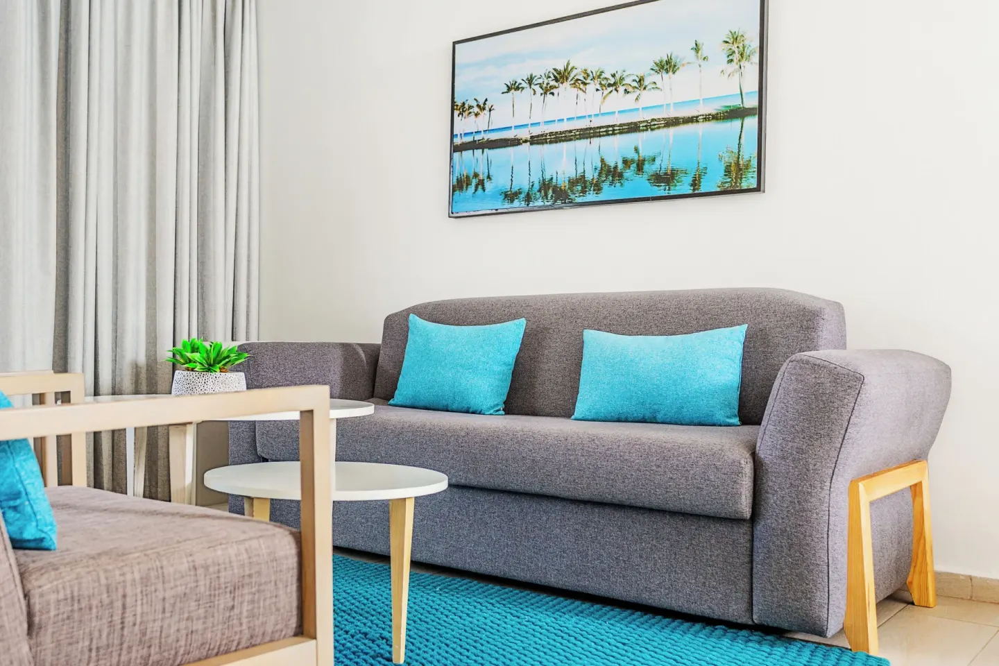 Corner Junior Suite sofa seating with turquoise pillows at Bahia Principe Escape Ambar.
