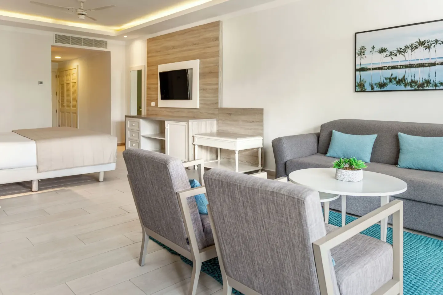 Sofa seating and TV in a Junior Suite Corner Swim Up at Bahia Principe Escape Ambar.