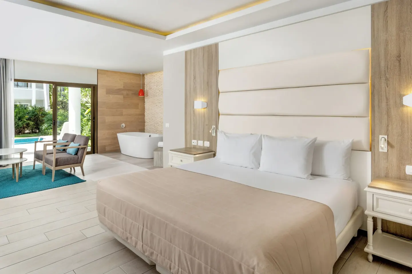 King bed and patio view in a Junior Suite Corner Swim Up at Bahia Principe Escape Ambar.