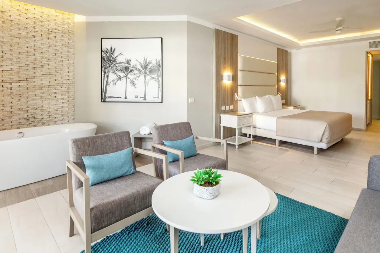 Seating area, tub, and king bed in a Junior Suite Corner Swim Up at Bahia Principe Escape Ambar.