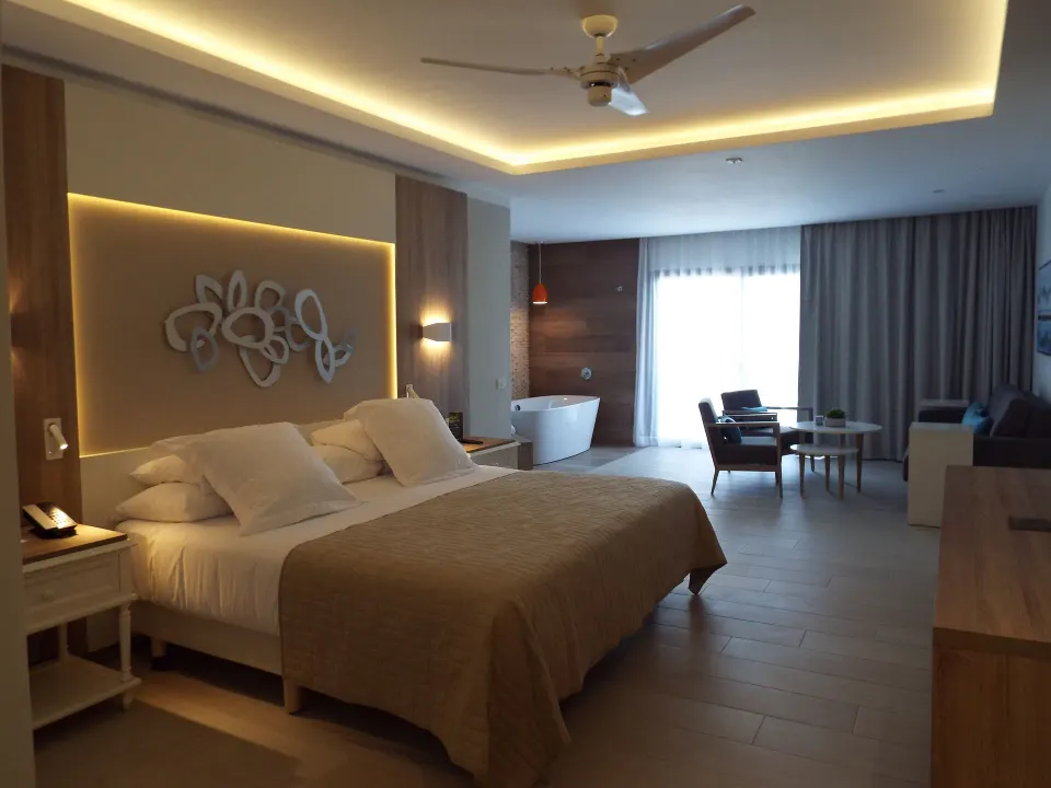 Junior Suite Deluxe Corner with king bed and seating at Bahia Principe Escape Ambar.