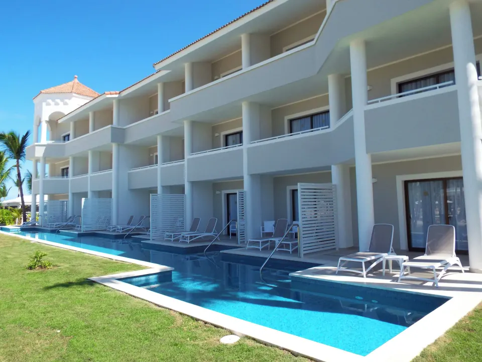 Exterior of swim-up Junior Suite terraces and shared pool at Bahia Principe Escape Ambar.