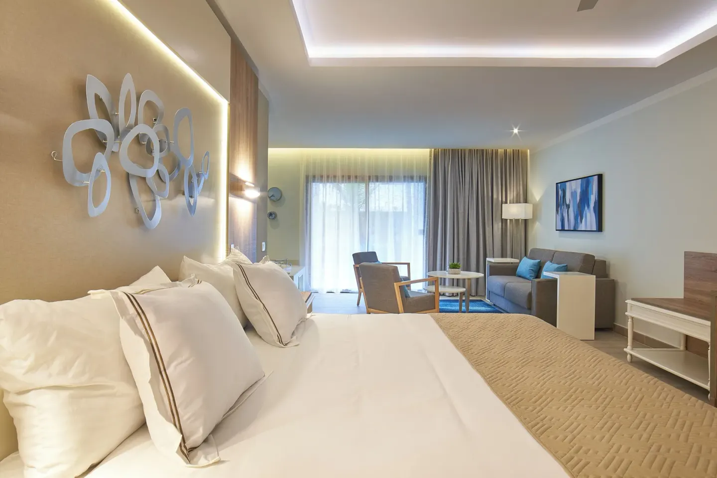 Junior Suite bedroom with king bed and sitting area at Bahia Principe Escape Ambar.