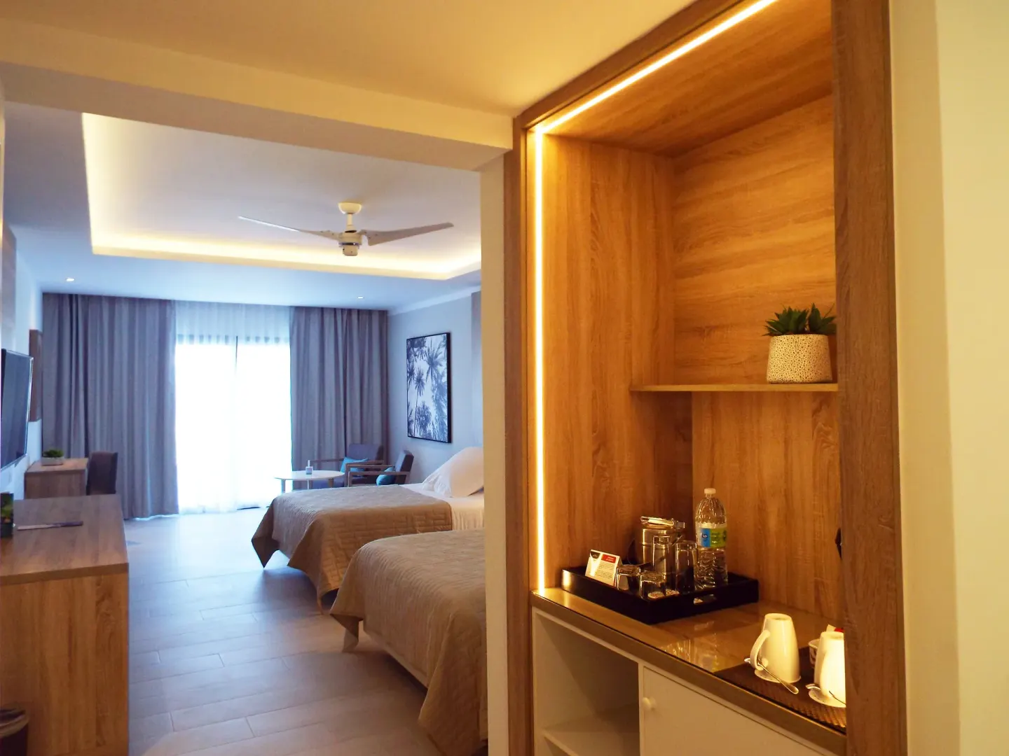 Junior Suite Deluxe entry with refreshment nook and two beds at Bahia Principe Escape Ambar.