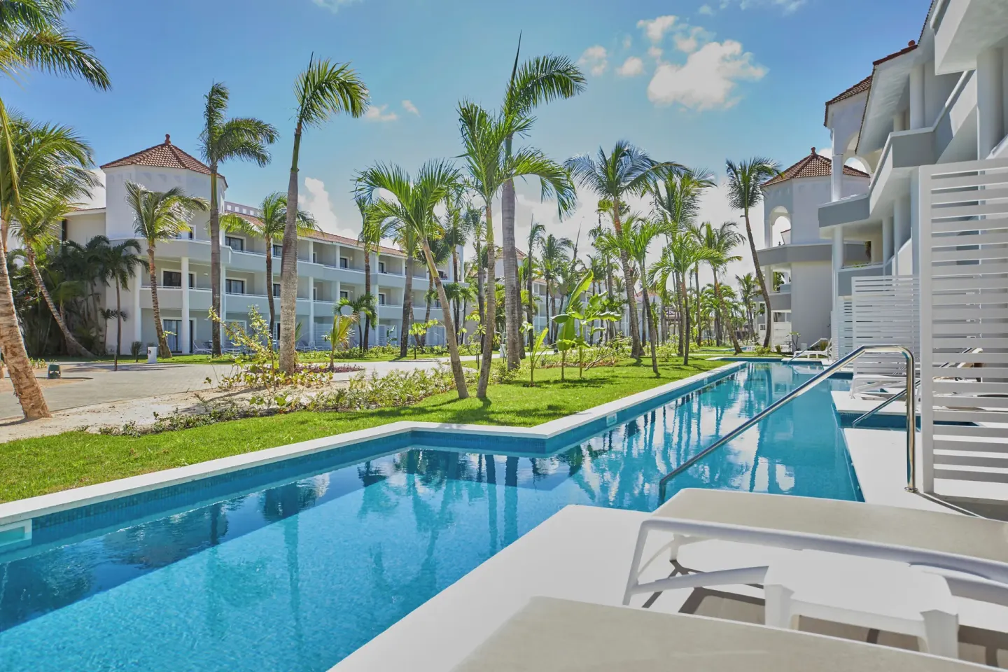 Junior Suite Swim Up poolside view with palms and room terraces at Bahia Principe Escape Ambar.