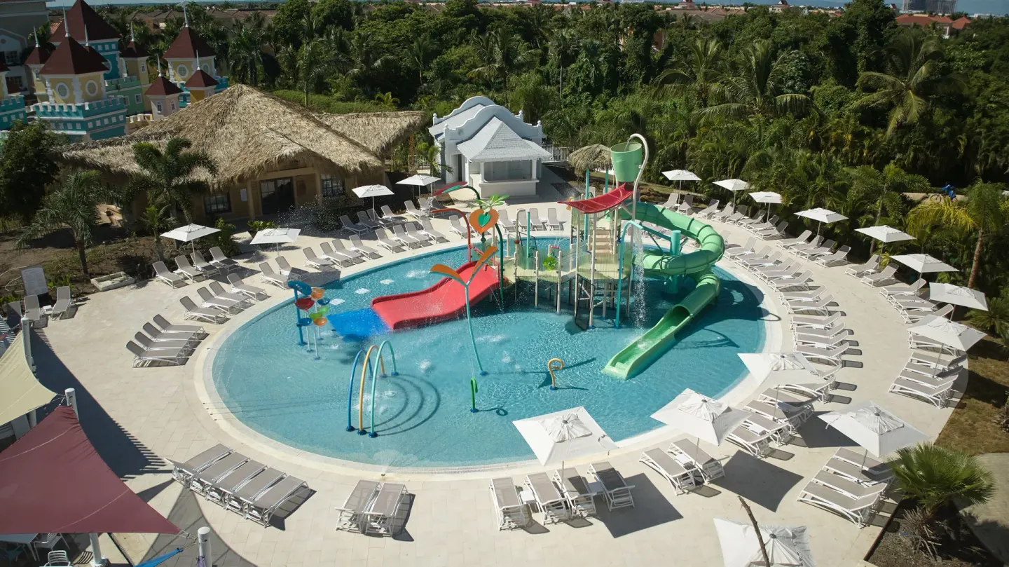 Aerial view of the children's pool with slides and surrounding loungers at Bahia Principe Explore Esmeralda.