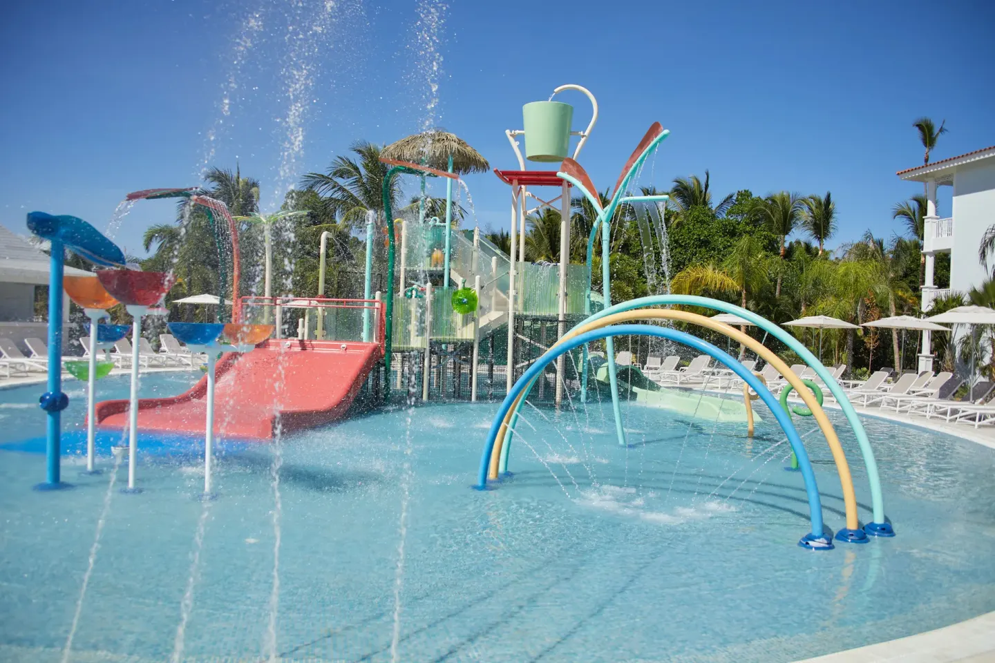 Empty children's splash pool with slides, spray arches and tipping buckets at Bahia Principe Explore Esmeralda.