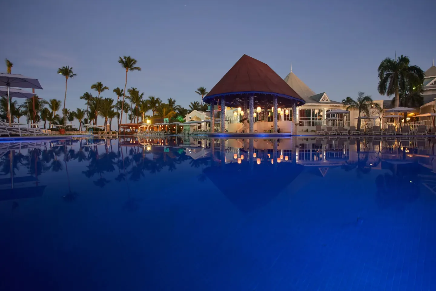 Low evening view across the illuminated pool at Bahia Principe Explore Esmeralda.
