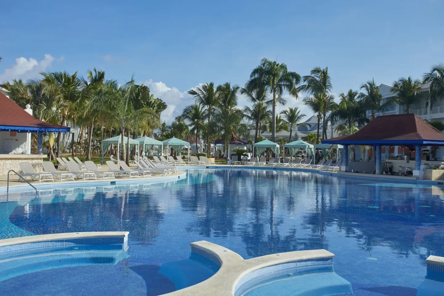 Large pool with swim-up bar pavilion and cabanas at Bahia Principe Explore Esmeralda.