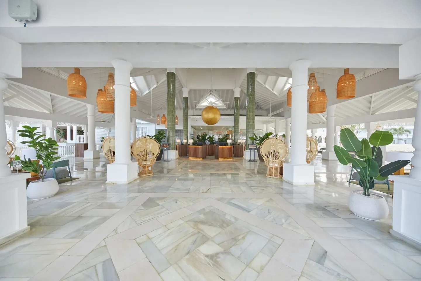 Spacious white lobby with seating and plants at Bahia Principe Explore Esmeralda.
