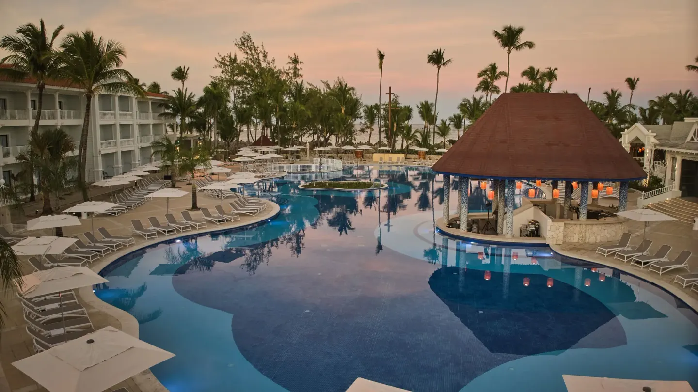 Pool and bar pavilion at sunset near the beach at Bahia Principe Explore Esmeralda.