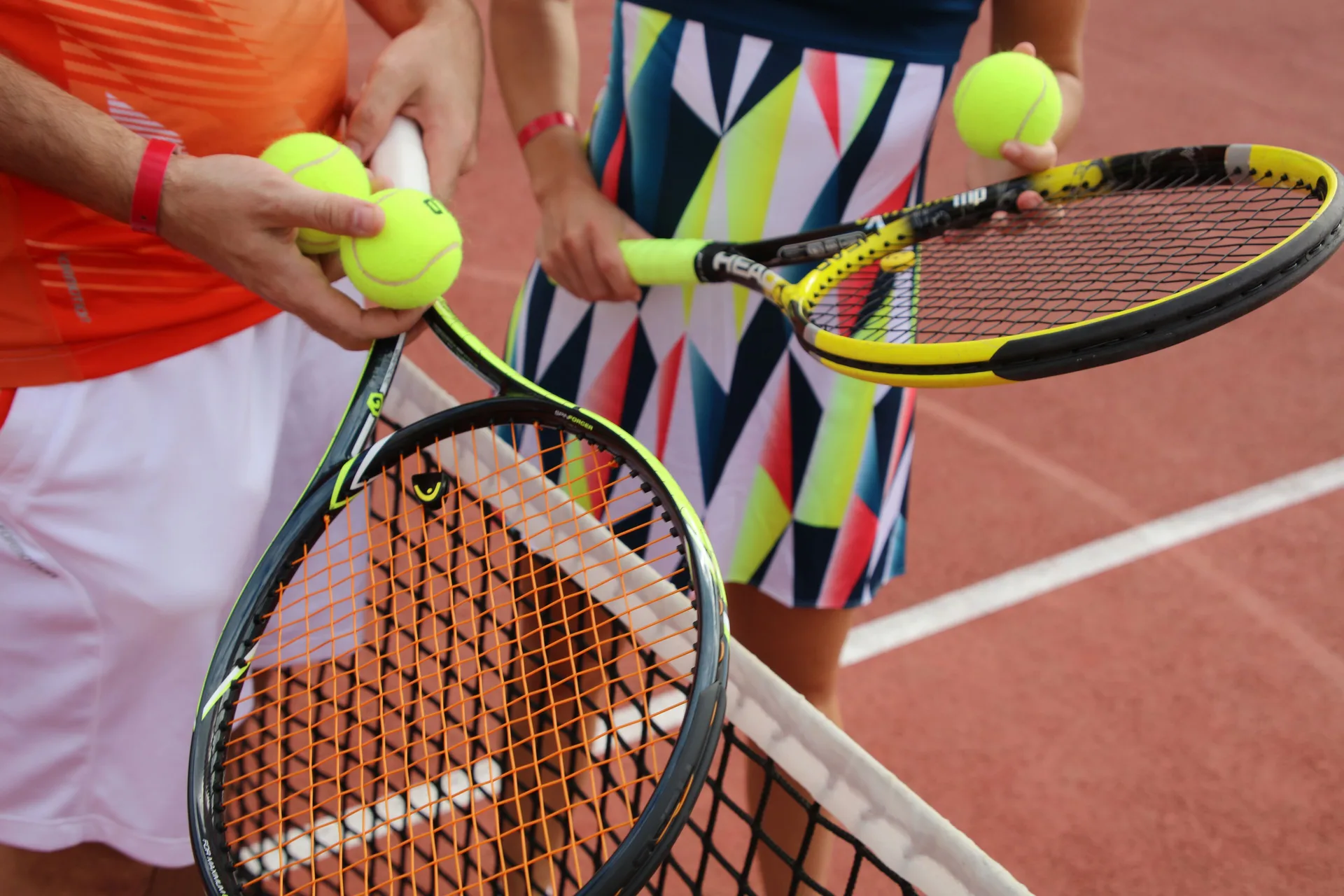 Guests holding tennis rackets and balls on a court at Bahia Principe Explore Esmeralda.