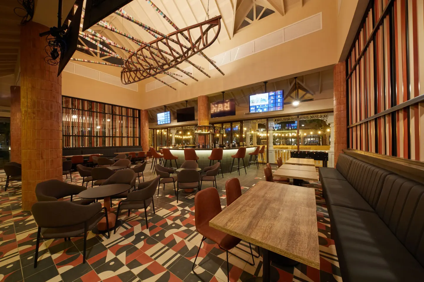 Sports bar with screens, lounge seating and patterned tile at Bahia Principe Explore Esmeralda.