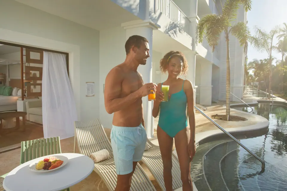Guests stand on a swim-up terrace outside a Junior Suite at Bahia Principe Explore Esmeralda.