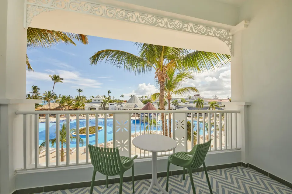 Junior Suite Deluxe balcony with pool and palm views at Bahia Principe Explore Esmeralda.