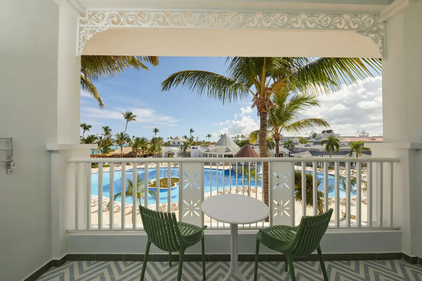 Junior Suite Deluxe balcony seating overlooking the pool at Bahia Principe Explore Esmeralda.