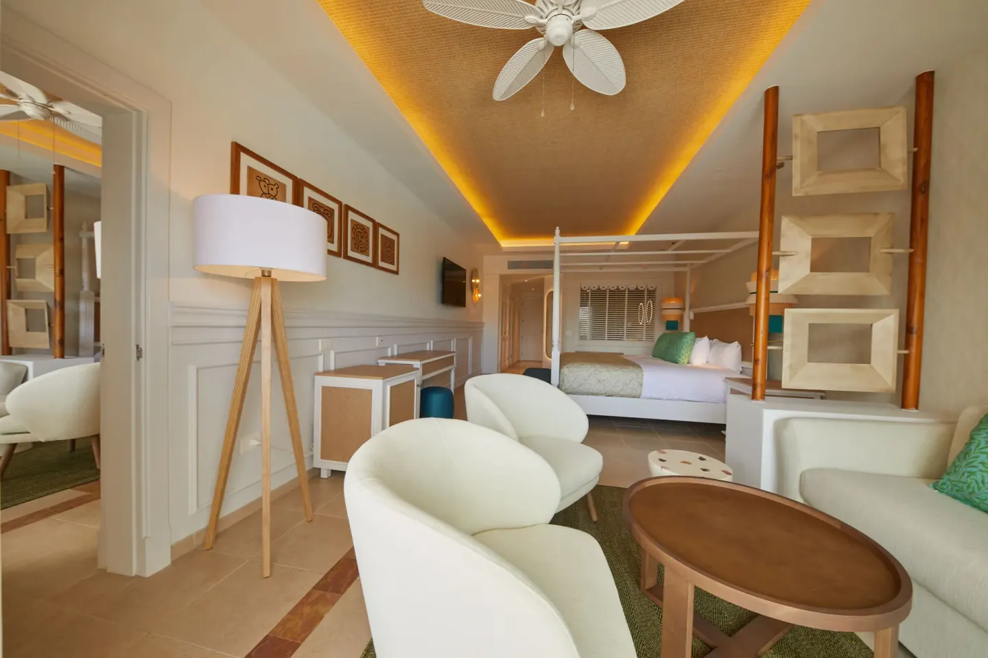 Junior Suite Deluxe with lounge seating, floor lamp and king bed at Bahia Principe Explore Esmeralda.