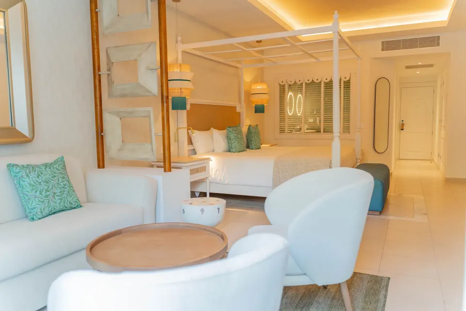 Junior Suite Deluxe with king bed, sofa and lounge chairs at Bahia Principe Explore Esmeralda.