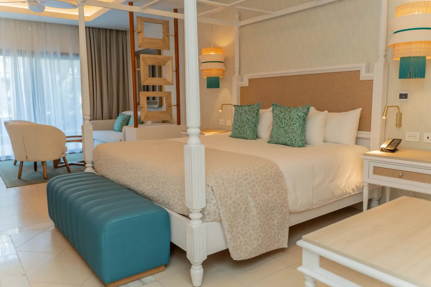 Junior Suite Deluxe king bed with lounge seating behind it at Bahia Principe Explore Esmeralda.