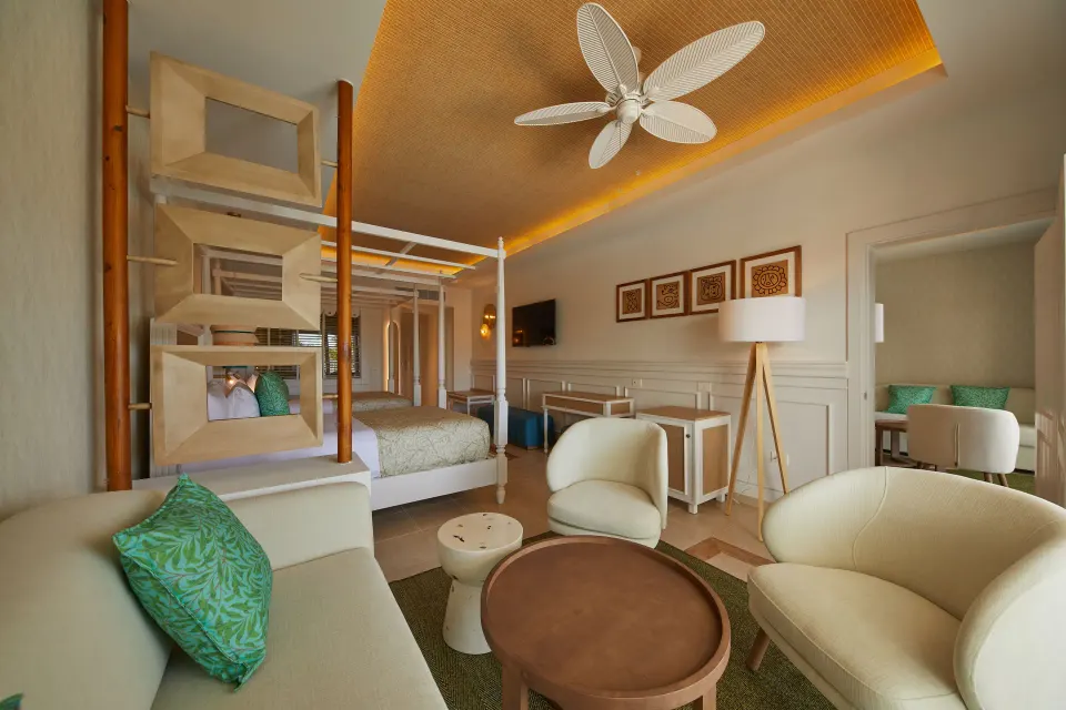 Junior Suite Deluxe lounge seating and king bed at Bahia Principe Explore Esmeralda.