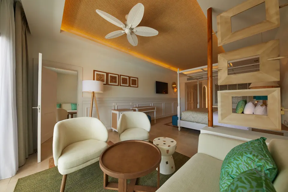 Junior Suite Deluxe seating area with king bed beyond at Bahia Principe Explore Esmeralda.