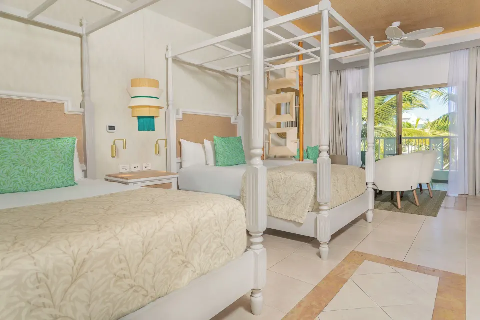Junior Suite Deluxe canopy beds near a balcony at Bahia Principe Explore Esmeralda.