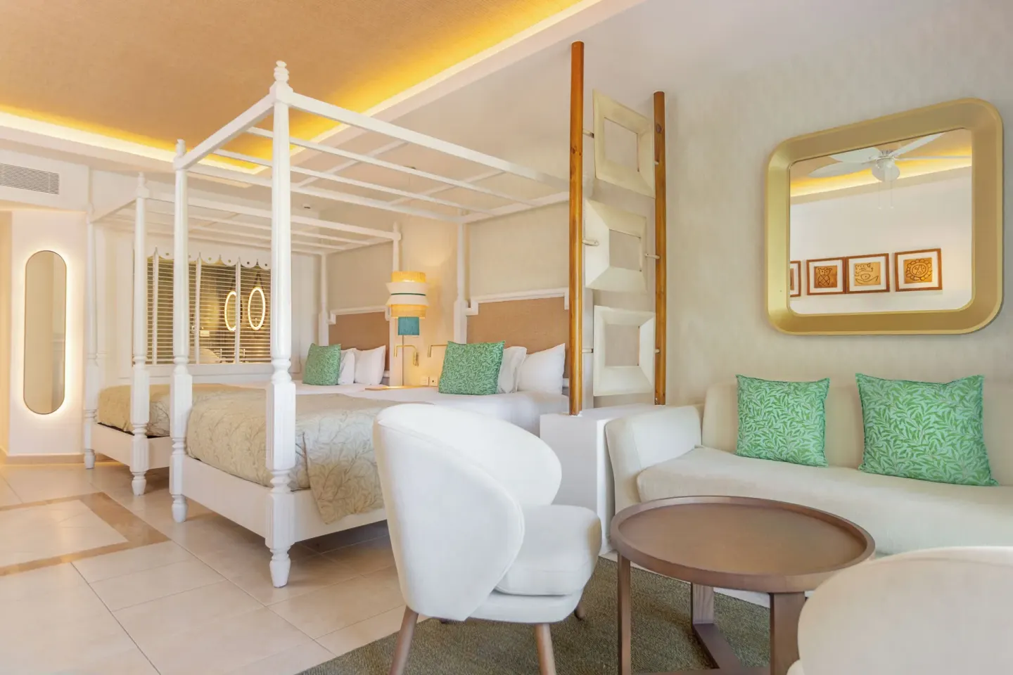 Junior Suite Deluxe seating area beside two canopy beds at Bahia Principe Explore Esmeralda.