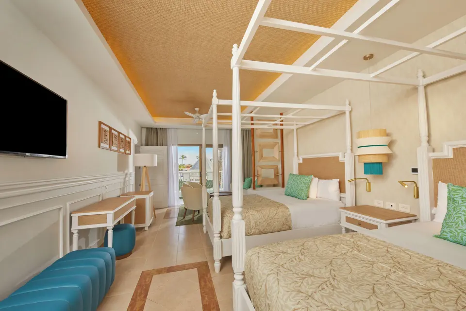 Junior Suite Deluxe with two canopy beds and TV at Bahia Principe Explore Esmeralda.