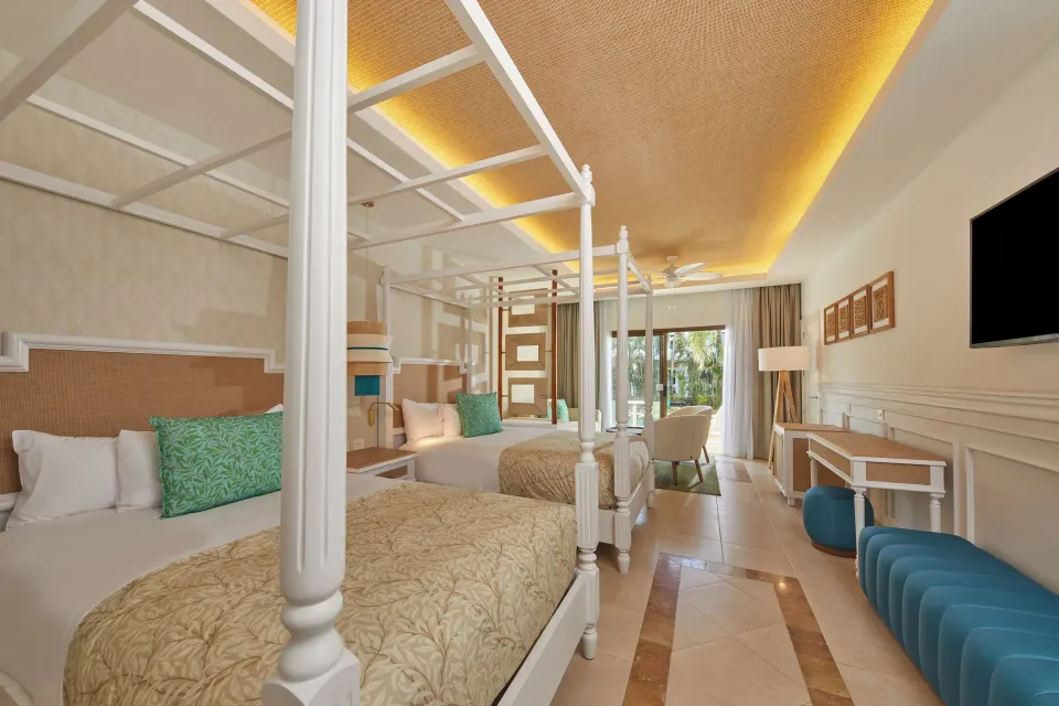 Swim-Up Junior Suite with two canopy beds at Bahia Principe Explore Esmeralda.